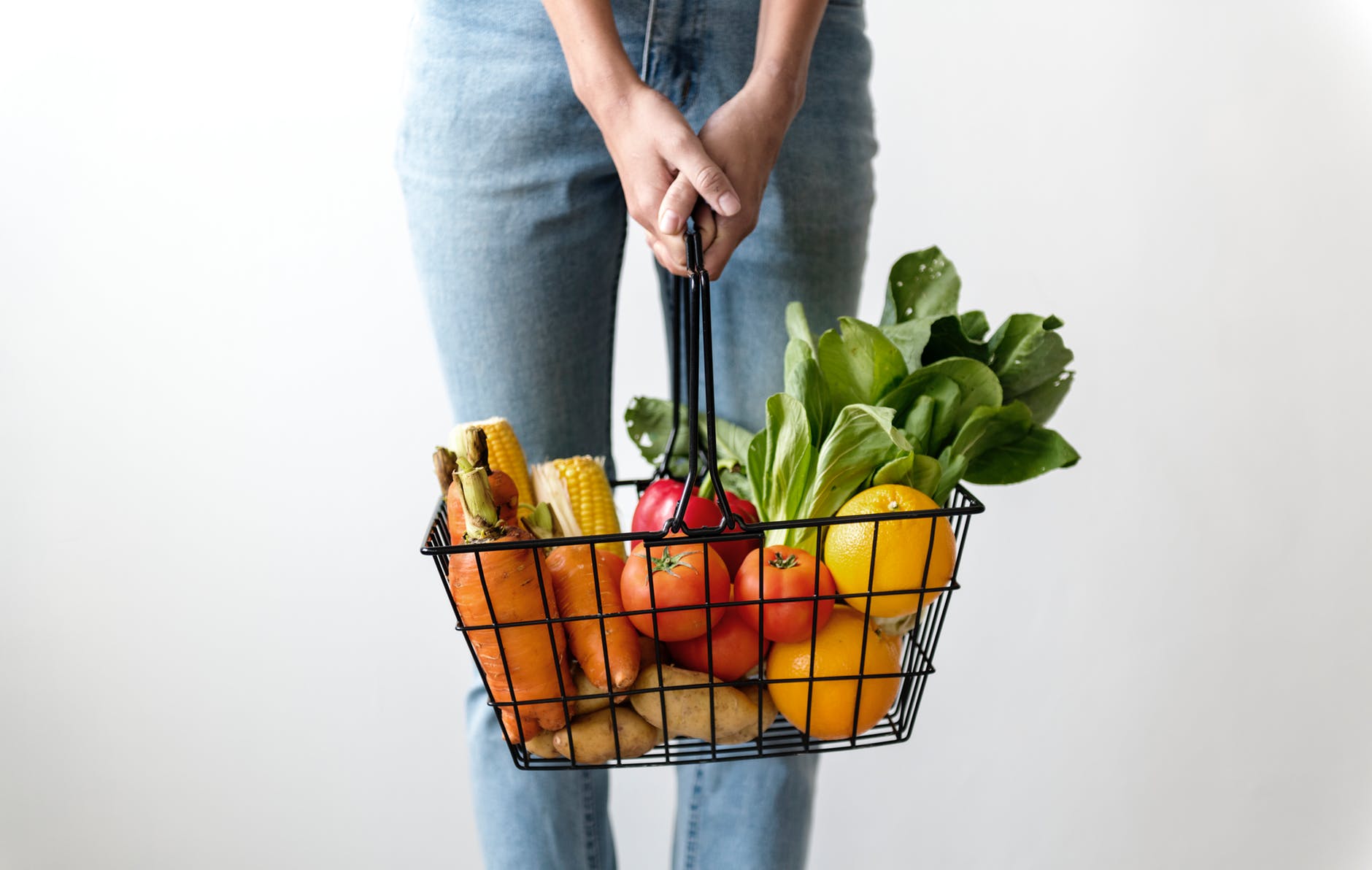 woman carrying basket of fruits and vegetables